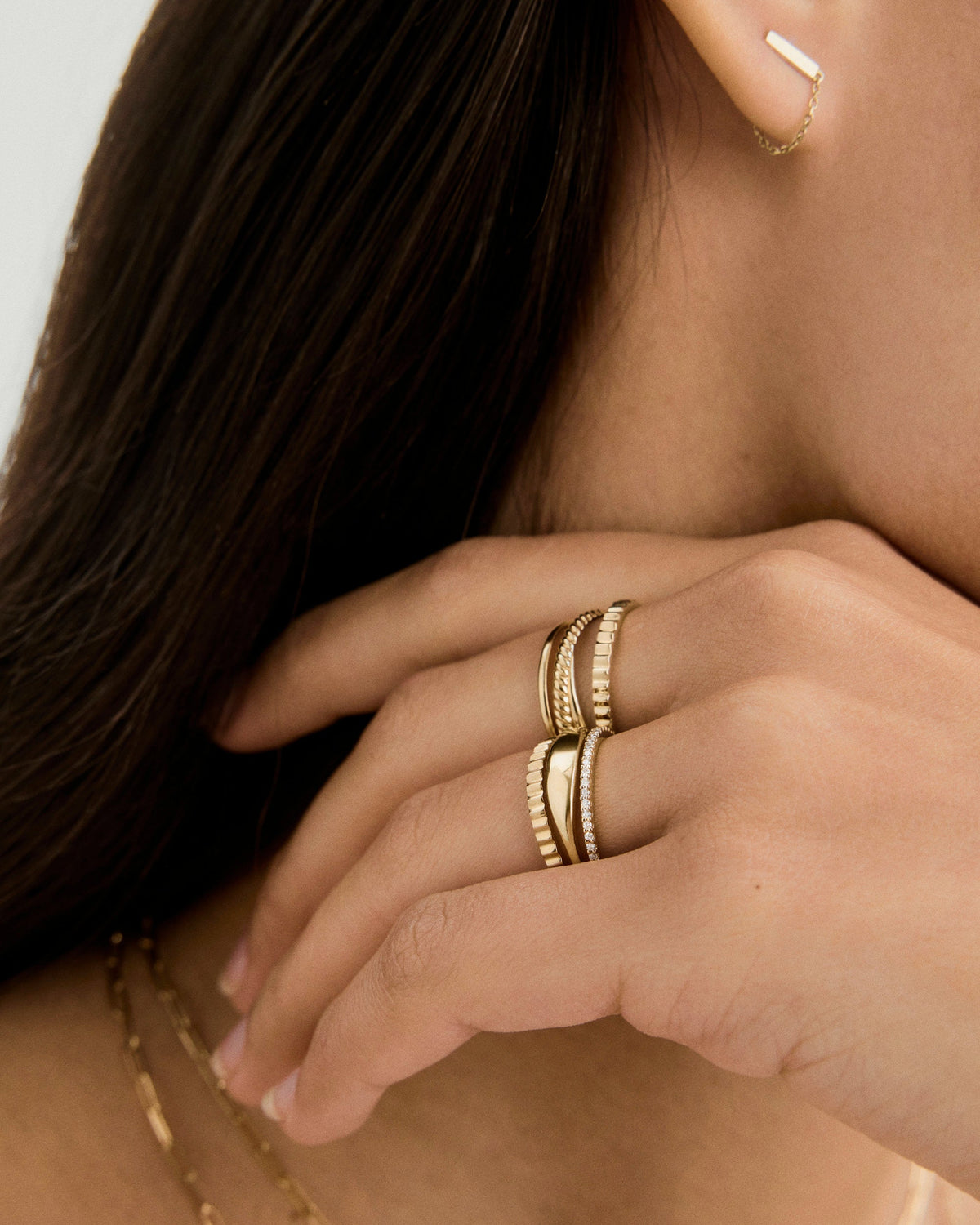 Mão usando anel aparador dourado em mix de anéis