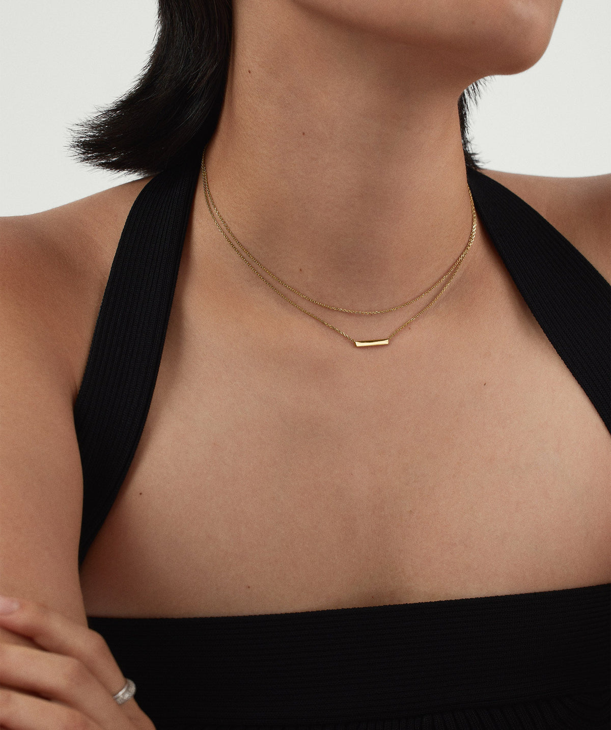 Mulher usando colar dourado em camadas