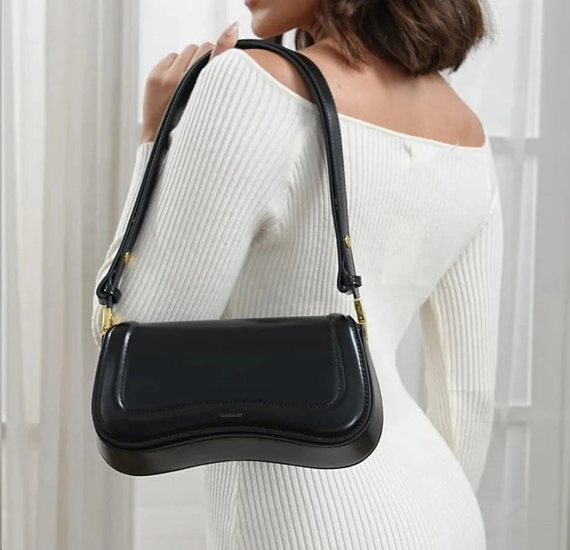 Modelo usando a bolsa de ombro ondulada preta
